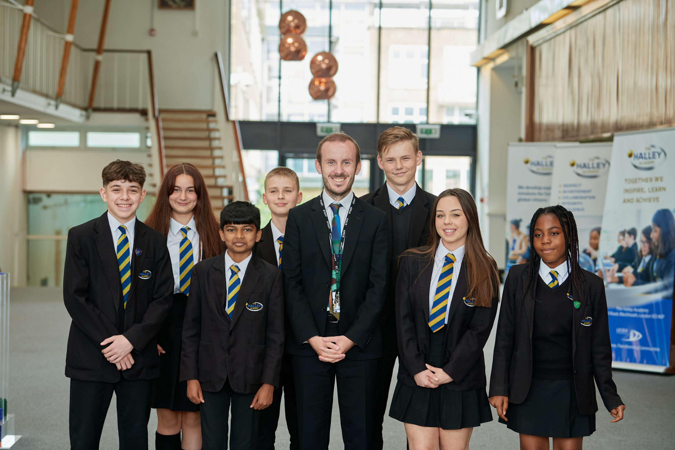 A group of children stood with the principal, smiling for a photo